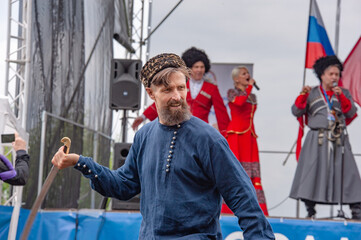 A Cossack with a bared saber flanks at the festival with the artists