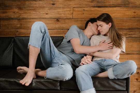 Young boyfriends kissing on sofa