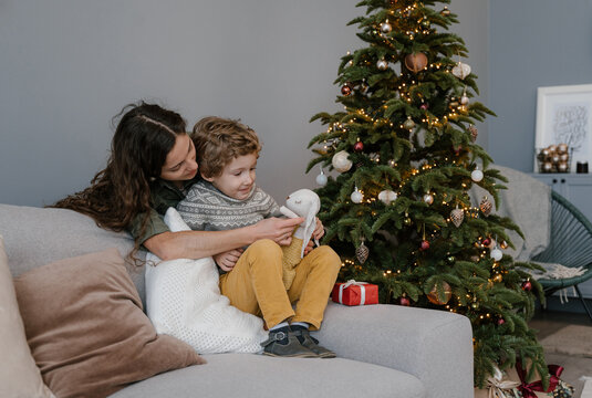 Mother and son playing near Christmas tree