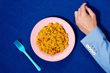 man hand and plate of cooked quinoa with vegetables