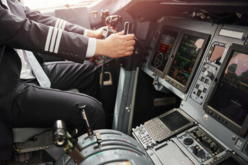 Male pilot use steering wheel to fly on airplane
