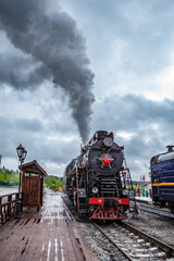 Vintage black steam locomotive train with wagons rush railway.