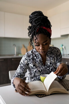 Black woman reading a book at home