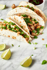 Tacos with meat and herbs, sauce and lime. National Mexican street food. On a light background.