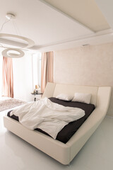 Fototapeta na wymiar Large bed inside contemporary luxurious hotel