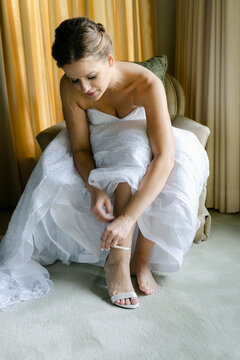 beautiful bride tying her shoes before  ceremony 