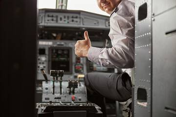 Pilot show thumb up gesture in cockpit of airplane