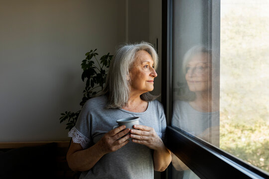 mature woman looking trough the window
