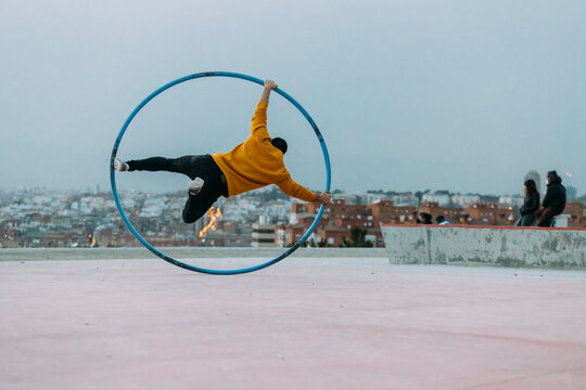 Young man performing in the street with a CYR Wheel