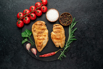 two grilled chicken breasts on a stone background