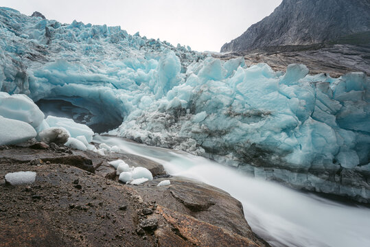 Rapid stream and melting glacier in mountains
