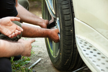 The mechanic changes the wheel of the car