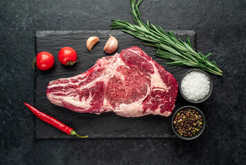 raw cowboy beef steak on stone background