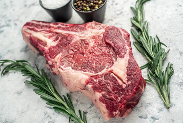 raw cowboy beef steak on stone background	