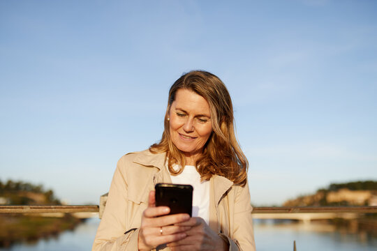 Mature woman reading a text outside