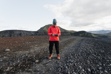 A hiker using a drone remote to take landscape shots of Iceland. 