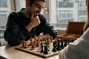 Young couple playing chess at home