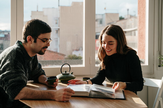 Young couple looking a photo album at home