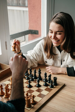 Young couple playing chess at home