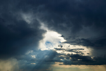 beautiful dark dramatic sky with sunlight and clouds as a background