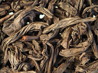 Close-up dry black tea leaves background. Top view