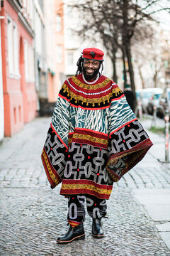 Cheerful African man in a tribal gown in an urban environment