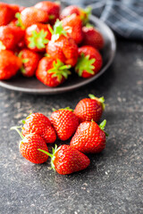 Whole ripe red strawberries on kitchen table.