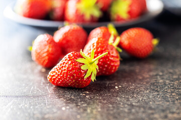 Whole ripe red strawberries on kitchen table.