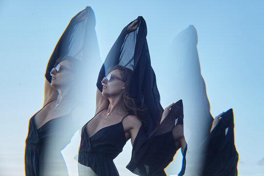 The girl in sunglasses on the background of the sky looking into the distance. Optical prism effect.