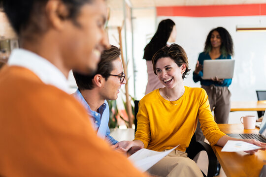 Coworkers Chatting In Modern Office