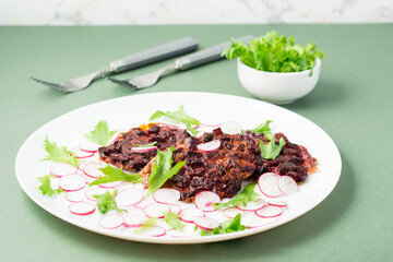 An alternative to meat protein is beet steak with vegetables and herbs on a plate. Flexitarian diet
