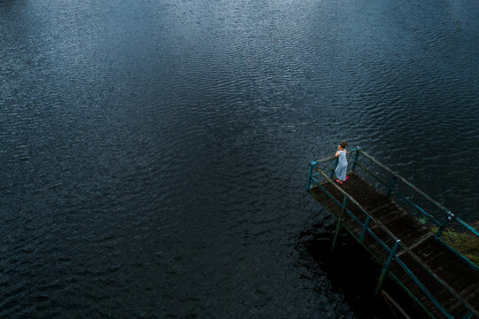 Girl Standing Alone On A Dock