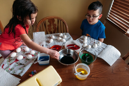Family decorating Easter eggs together. 
