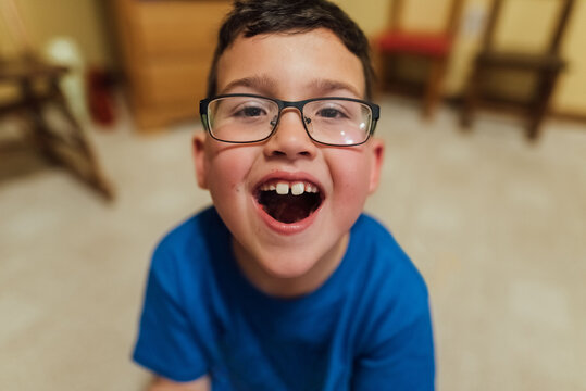Boy showing off the candy in his mouth. 