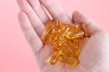 Hand holds omega-3. Handful of vitamins in hand