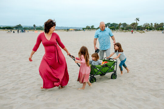 Mom and daughter pulling wagon across sand