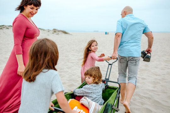 Family heading to beach with green wagon