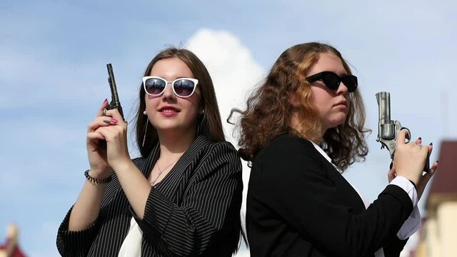 Girlfriends-secret agents in black glasses with guns in their hands