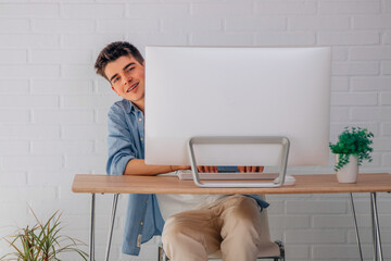 satisfied male teenage student at desk with computer