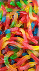 A group of sugar coated sour tasting colorful gummy worms