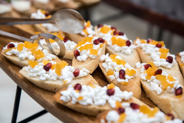 Sandwiches with coarse-grained homemade cottage cheese, tangerine pieces and pomegranate seeds