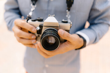 anonymous man holding in hands retro camera