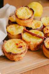 Portuguese egg custard tart with towel background and cinnamon stick and lemon - Pasteis de Nata or Pastel de Belem
