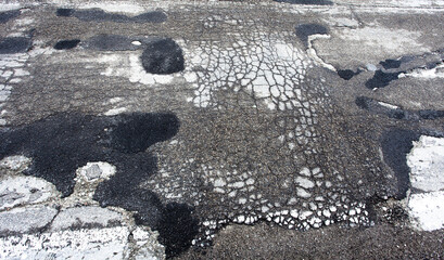 broken or damaged asphalt on he road. car insurance concept