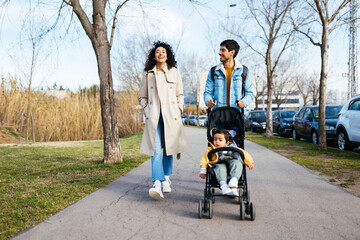 Optimistic Indian family walking on path in park