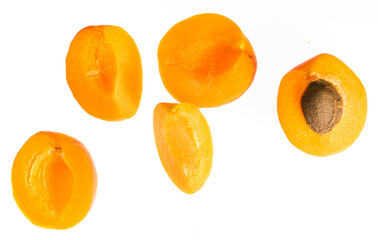 Fototapeta na wymiar Pieces of ripe apricot fruit, halves and fourth part, on a white background in isolation