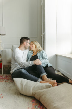 Husband and wife cuddle on the ground