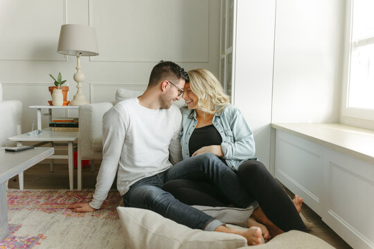 Husband and wife cuddle on the ground