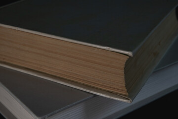 Books with gray covers in the dark, close-up