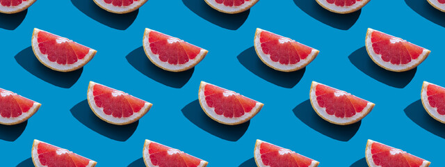 Seamless pattern of orange grapefruit with shadow on a blue background. Banner. Summer vacation minimal trendy concept. Healthy eating habits.
